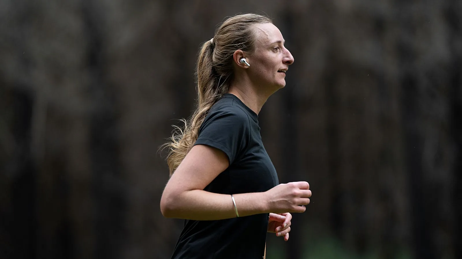 Persona che corre all'aperto con auricolari wireless, scena illustrativa per lo scenario sportivo.