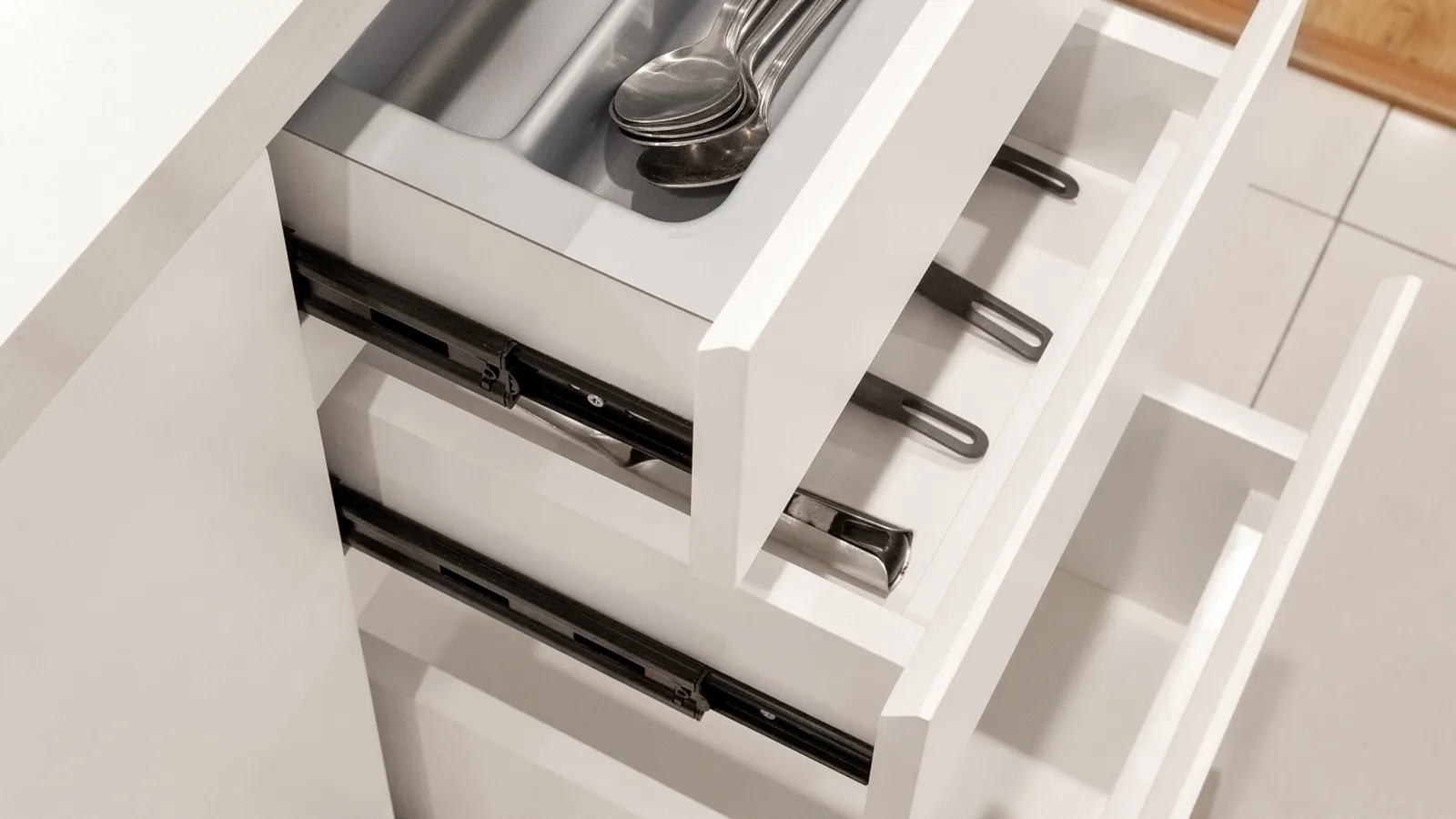 Cassetti della cucina aperti con posate sistemate in un divisorio.