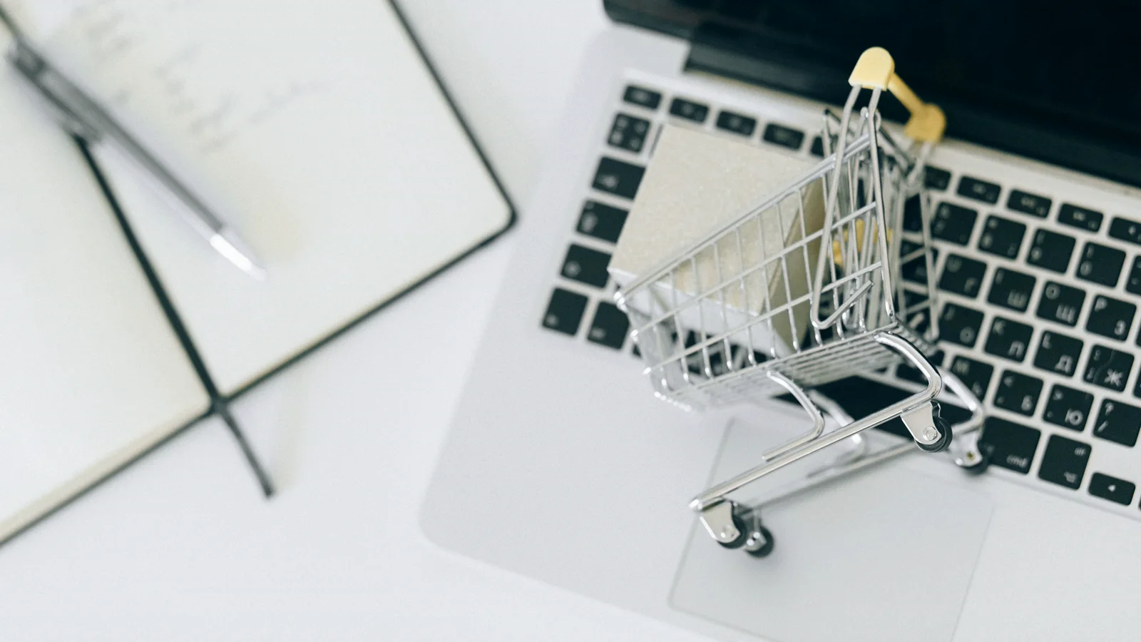 Carrello in miniatura sulla tastiera di un laptop come simbolo di una scelta online da valutare.